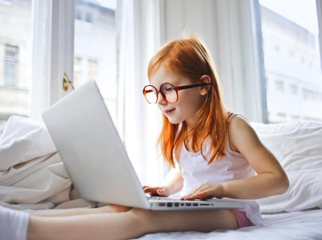 picture of girl on laptop while sitting in bed